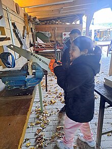 Foto Kind mit Säge am Schraubstock