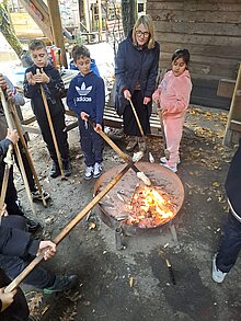 Foto Kinder mit Betreuerin beim Stockbrotbacken