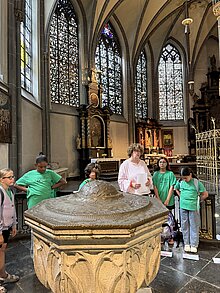 Foto: Kinder feiern die Abschlussrunde am Taufbecken von St. Lambertus.