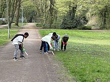 Kinder sammeln Müll im Park.