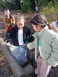 Foto Mehrere Kinder sammeln Müll im Garten.