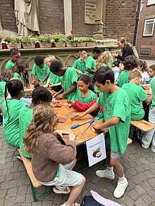 Foto: Kinder schmirgeln Kokosnussschalen glatt.