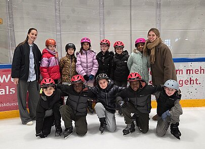 Foto Kinder und Lehrer beim Eislaufen